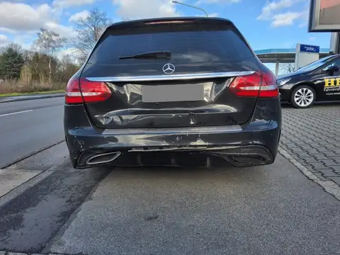 Schwarze Mercedes C-Klasse mit Heckschaden